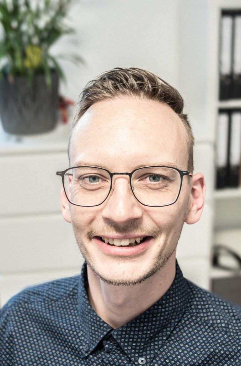 Immobilienmakler Christopher Beyer mit einem Lächeln aus Gold 